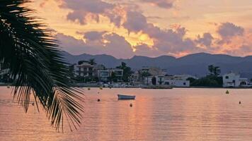 Village by the water against the backdrop of mountains, sunset pink video