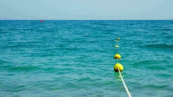 Visão do amarelo bóias em a praia, lindo água video