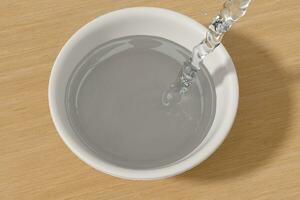 A bowl of water and splashing liquid, 3d rendering. photo