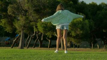 Girl spinning in a beautiful park at sunset video