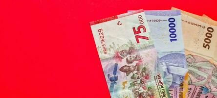 Top view of new banknotes issued in 2022. Indonesian rupiah currency isolated on red background photo