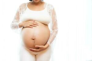 retrato de un embarazada mujer conmovedor su grande barriga cerca arriba, madre, el embarazo, personas y expectativa. mujer participación grande embarazada estómago foto