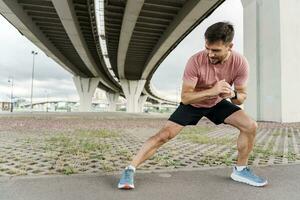 trainer in full-length fitness clothes, running sports shoes and fitness watches. Motivation a male athlete photo