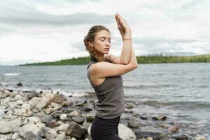 Mental health female coach meditates, yoga pose training in nature. Harmony and balance and zen. photo