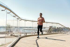 A male runner uses a fitness bracelet for a cardio trainer athlete measured in the app. training outside in sportswear. Healthy lifestyle and mental health. photo