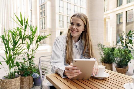 The assistant is a female administrator going to work, using a tablet in her hands. Works remotely online uses the company's app to communicate. Writes a letter to the client by mail. photo