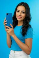 Stunning woman holding a mobile phone with a bright background. Pro Photo