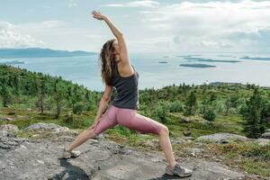 Uses mat meditation and mental health of a person, the trainer is engaged in asana Pilates and stretching a slim body.  Young woman yoga workout. The asana pose is harmony with nature. photo