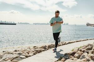 A running athletic person in athletic shoes, using a smart fitness watch on his arm, running training, uses the app. Male trainer in fitness clothes. photo