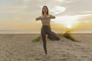 Meditation and harmony and balance of a person, mental health. The woman is slender, flexible body, practicing yoga exercise beautiful asana. Fitness on the background of sunset. photo