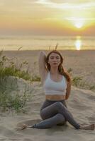 A female trainer uses fitness clothes for exercise. Meditation and harmony. A healthy lifestyle is mental health, the life of a modern person.  Does the asana pose workout outdoors. photo