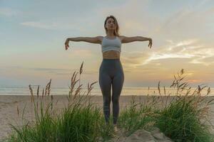A healthy lifestyle is mental health, the life of a modern person. Meditation and harmony. Does the asana pose workout outdoors. A female trainer uses fitness clothes for exercise. photo