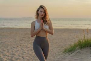 Meditative harmony and balance of a person, mental health. The woman is slender, flexible body, practicing yoga exercise beautiful asana. Fitness on the background of sunset. photo