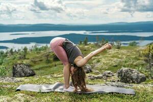 Young woman yoga workout. The asana pose is harmony with nature.   Diet and exercise.  Uses mat meditation and mental health of a person, the trainer is engaged in asana Pilates and stretching photo