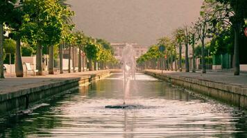 Brunnen im ein lange Kanal gegen das Hintergrund von ein Gasse und Berge video