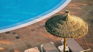 Haut vue de le piscine, Soleil chaises longues et parapluie fabriqué de paume branches video