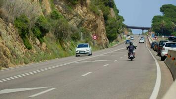 A motorcyclist and a car are driving along the road video