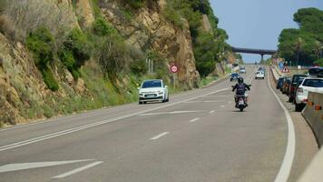 ein Motorradfahrer und ein Auto sind Fahren entlang das Straße video