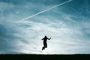 man silhouette feeling free among clouds in the mountain photo