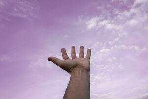 mano arriba gesticulando en el rosado cielo, sentimientos y emociones foto