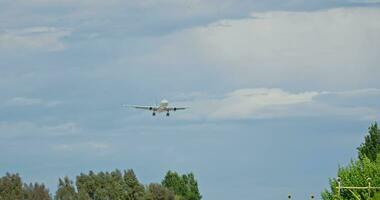 A plane flying over a picturesque field with a backdrop of tall trees video