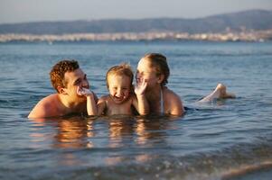 Laughing little boy with his parents at the sea photo