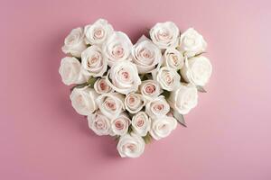 Bouquet of white roses in the shape of a heart on a pink background. photo