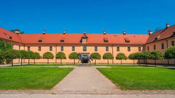Moritzburg, Saxony, Germany - JOld stable with monument of horse near famous ancient Moritzburg Castle, main entrance, near Dresden at sunny summer day with blue sky photo