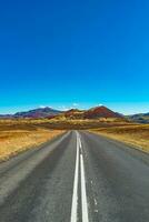 cubrir página con un pavimentado la carretera y islandés vistoso y salvaje paisaje con fiordos y mar a verano tiempo, Oeste Islandia foto