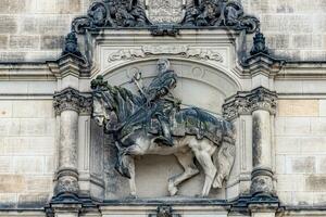 Dresden, Germany - Ancient sculpture of scary, fearful and heavy armed gatekeeper, medieval warrior, knight at horse in historical downtown, details, closeup. Authentic European old architecture. photo