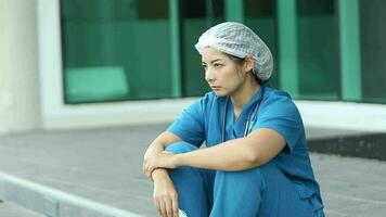 chateado enfermeira sentado em chão dentro hospital enfermaria video