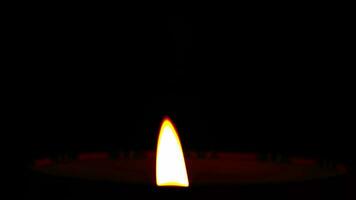 Close-up of candle flame burning on a black background. video