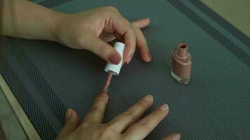 femme mains avec clou polonais sur table à maison, moment de relaxation, auto-peinture ongles video