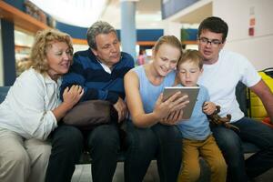 Big family entertaining with touch pad at the airport photo