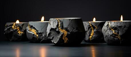 Abstract smudges and cracks adorn a set of stone candle holders featuring a golden flame amidst black concrete with a slightly blurred foreground photo