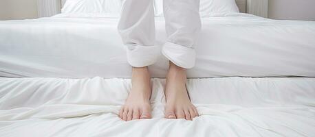 Feet and toes treading on the white wrinkled bed sheets photo