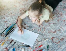 Child girl drawing with colorful pencils photo