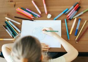 Child girl drawing with colorful pencils photo