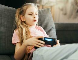 niña jugando vídeo juego a hogar foto