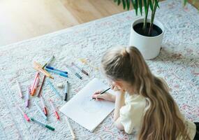 Child girl drawing with colorful pencils photo