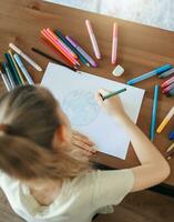 Child girl drawing with colorful pencils photo