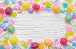 Sweet lollipops and candies on white wooden background photo