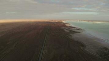 Straight road by the salt lake with wide flatlands background. video