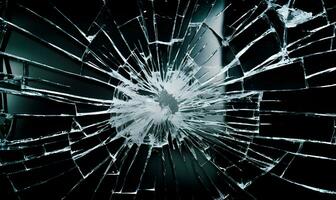 Broken glass with hole due to gunshot. Concept of fragility and violence. photo