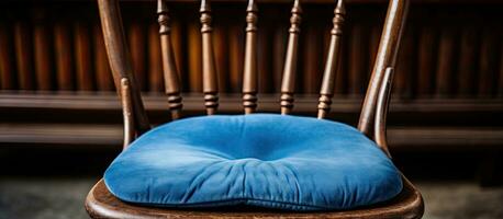Close up of an aged chair featuring a blue cushion photo