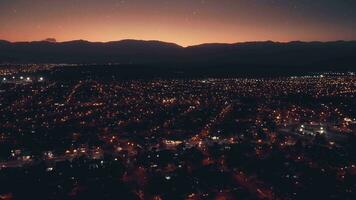 aéreo zangão vôo sobre noite Salta cidade dentro Argentina. pôr do sol. cidade noite luzes. video