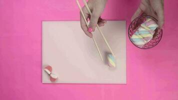 Flat lay top view of candy sushi on pink background video