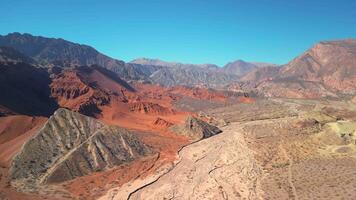 aereo Visualizza fuco volante al di sopra di panoramico rosso roccioso montagne paesaggio con un' chiaro blu cielo. video