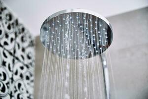 Water flowing from shower head in bathroom photo