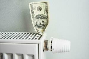 Close up of heating thermostat with dollar banknotes, Rising gas costs photo